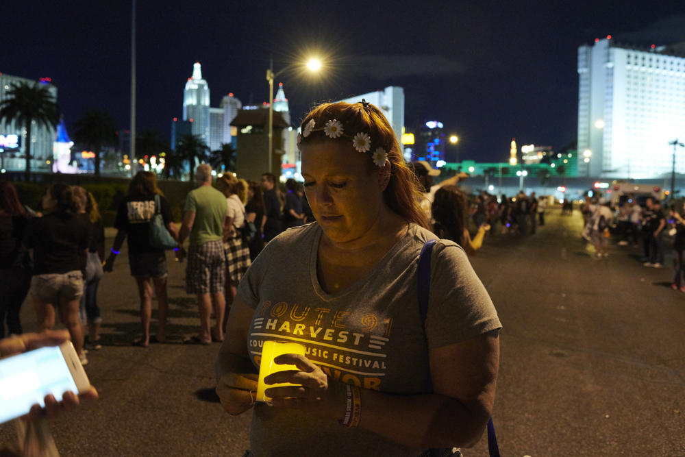 Heather Gooze holds a candle in a flower crown she was wearing the night of the shooting during a gathering one year after the Route 91 shooting on Oct. 1, 2017.