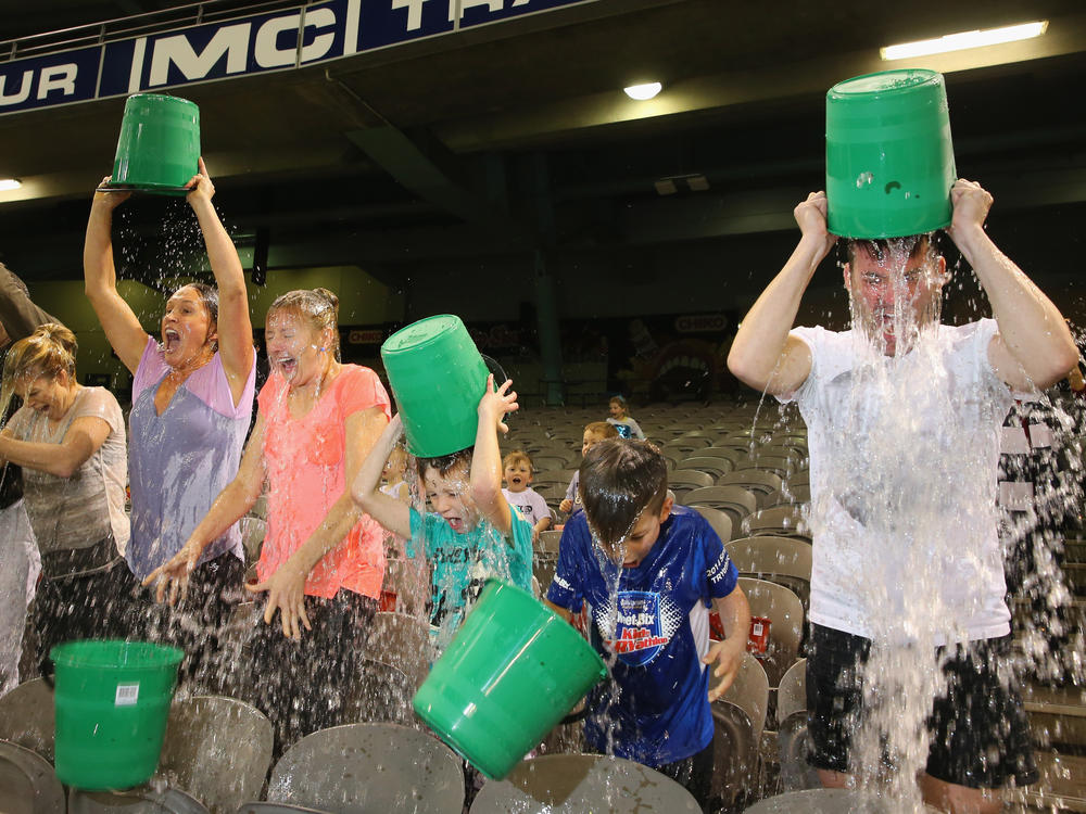 Participants tip buckets of ice water over their heads as they take part in the World Record Ice Bucket Challenge at Etihad Stadium on Aug. 22, 2014, in Melbourne, Australia.
