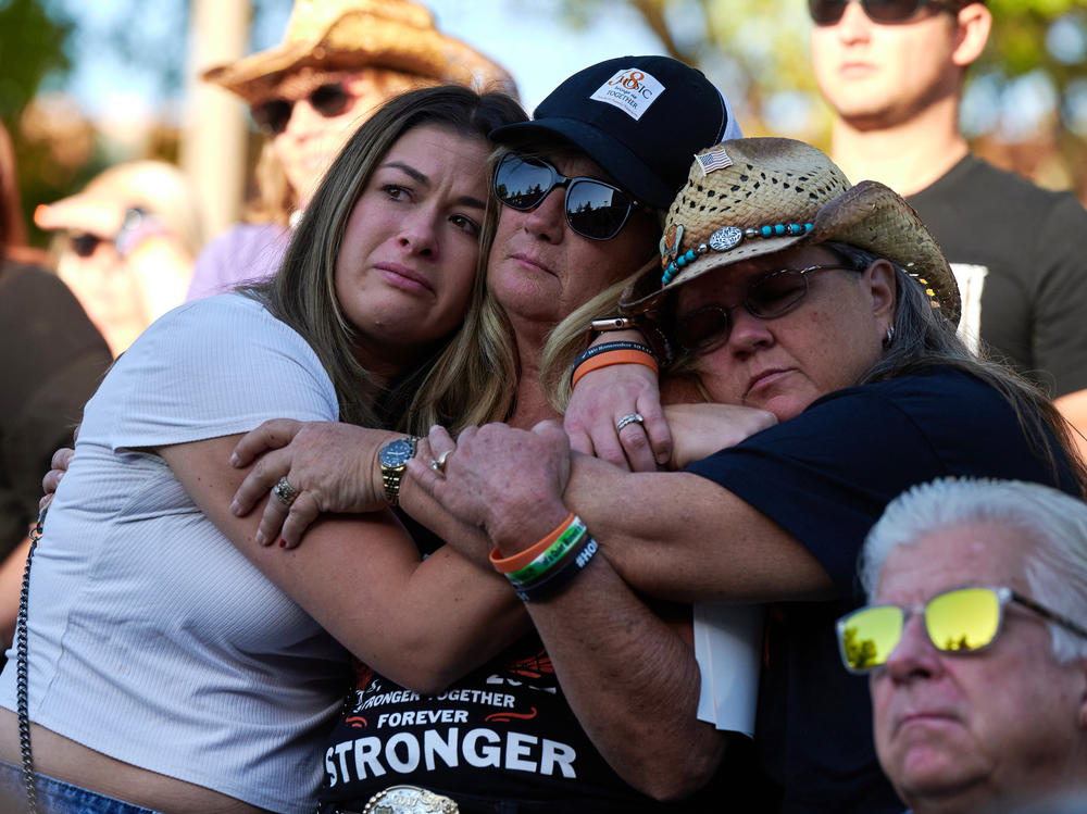 Lauren Reh, Alicia Mierke and Sue Ann Cornwell embrace during the Sunrise Remembrance ceremony at Clark County Government Center Amphitheater in Las Vegas on Oct. 1, 2022.
