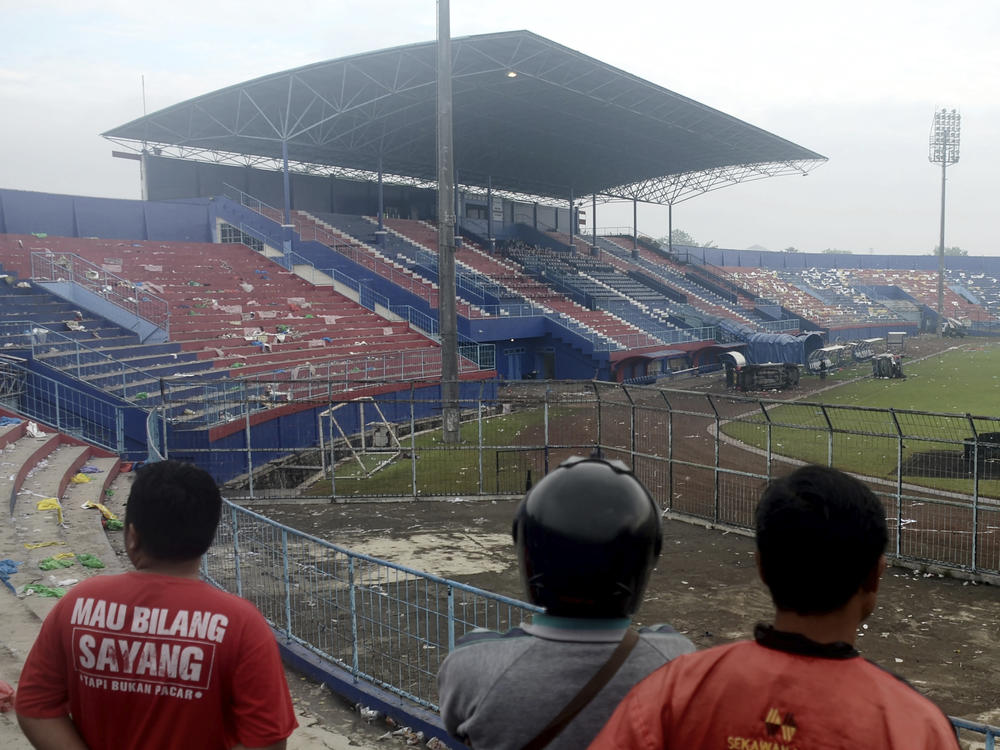 People examine the damage following a soccer match stampede at the Kanjuruhan Stadium in Malang, East Java, Indonesia.