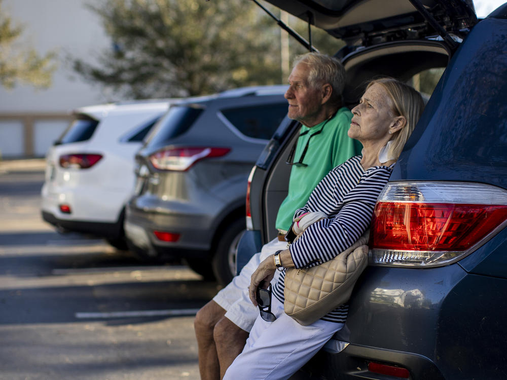 Jim and Susan Helton sit int he back of a car outside a hotel in Fort Myers, Fla. Their home in Fort Myers beach was destroyed by Hurricane Ian.