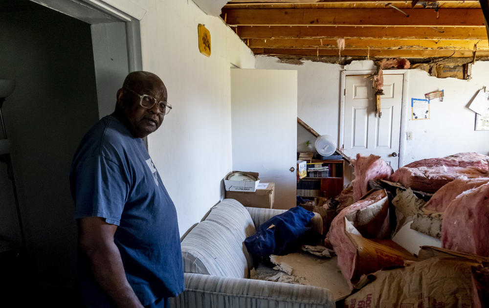 Jesse Howard shows the damage to Earline McCoy's home in the Dunbar neighborhood of Fort Myers, Fla., after Hurricane Ian passed through the area.