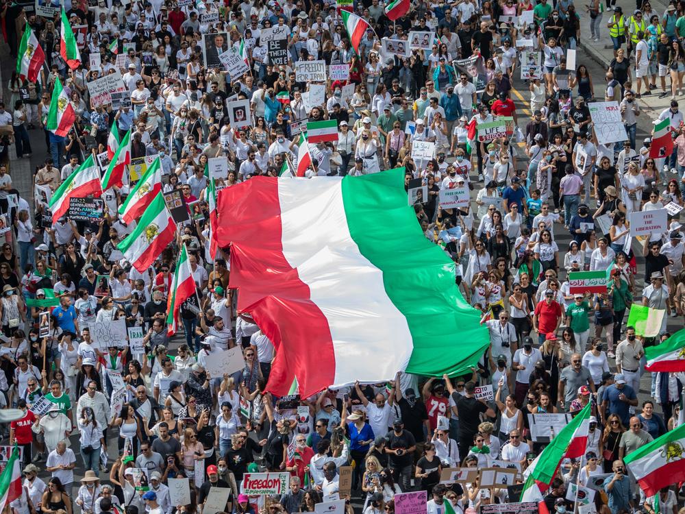 Demonstrators in Los Angeles on Saturday hold Iran's flag during a protest for Mahsa Amini who died last month in custody of Iran's morality police.