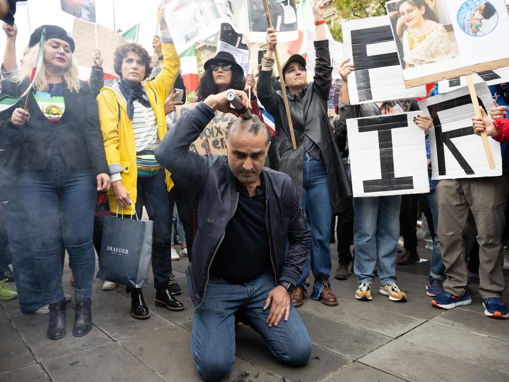 A man shaves his head during a demonstration in support of Kurdish Iranian woman Mahsa Amini during a protest on Sunday on Place de la Republique in Paris.