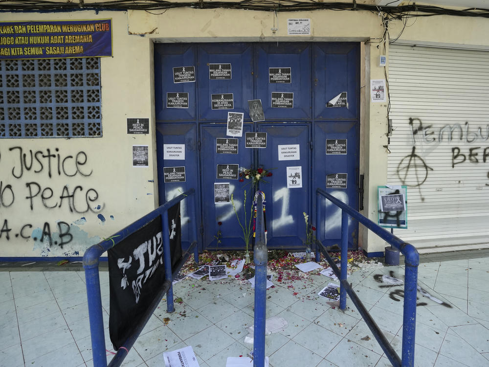 Protest signs cover a gate at the Kanjuruhan Stadium in Malang, Indonesia on Tuesday. Police said the gates at the soccer stadium could only accommodate two people at a time when hundreds were trying to escape.
