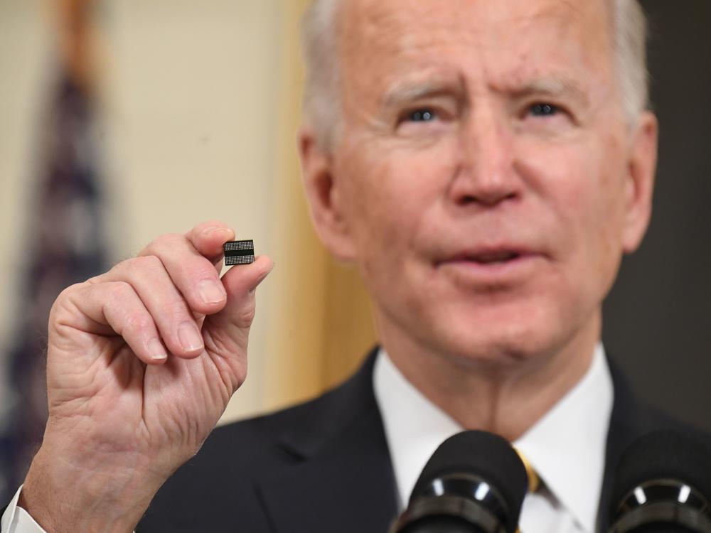President Biden holds a semiconductor chip in this 2021 file photo. The White House is working out how to spend $52 billion that Congress has provided to spur U.S. chip manufacturing plants.