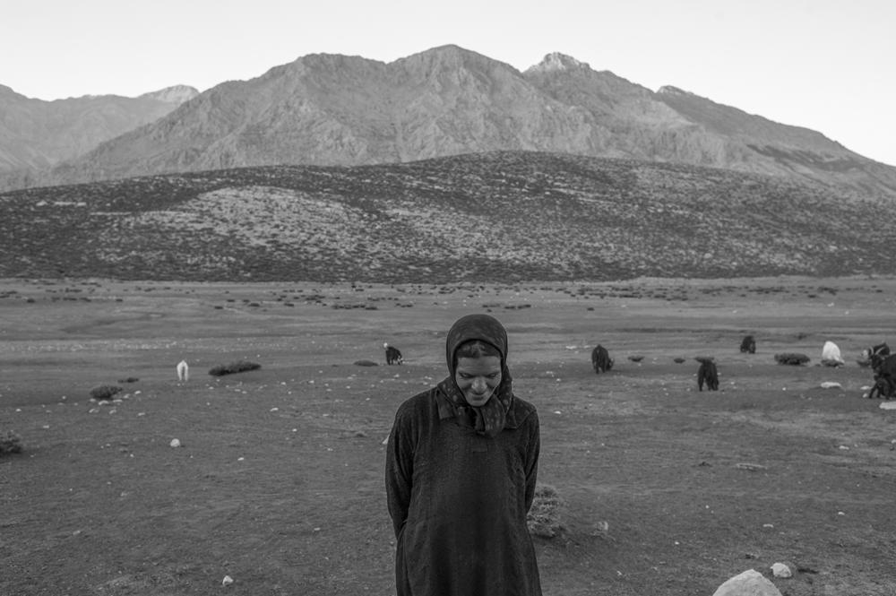 Jamileh, who's 50, stands on a mountain slope near her dwelling place.