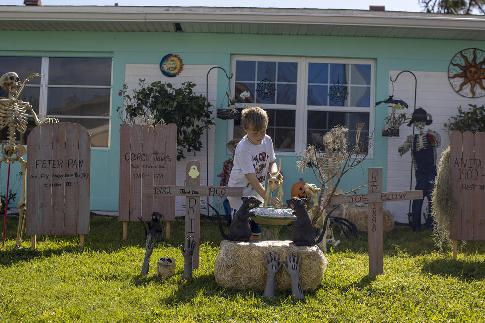 Hunter Peck adjusts Halloween decorations at his grandparents' home in North Port, Fla., on Wednesday.