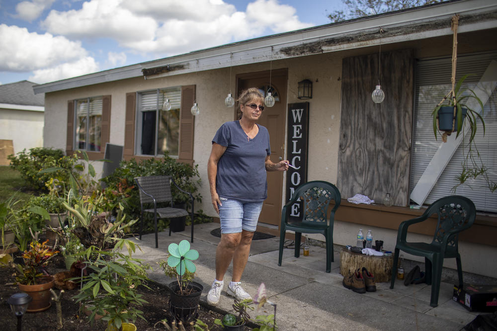 Alva Sulaty stands in front of her home in North Port, Fla., on Wednesday, Oct. 5, one week after Hurricane Ian roared through her neighborhood.