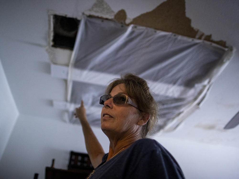 Alva Sulaty points to the damage in her home in North Port, Fla., on Wednesday, after Hurricane Ian flooded her neighborhood.
