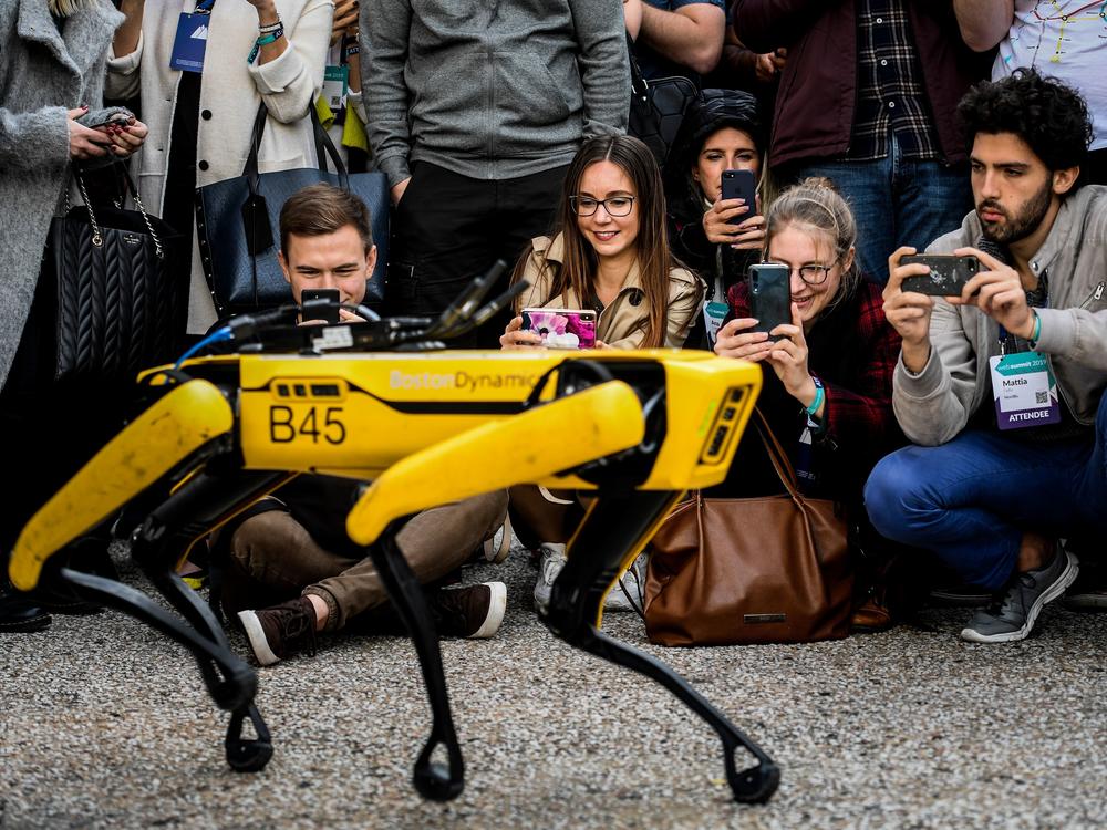 People take pictures and videos of the Boston Dynamics robot Spot during an event in Lisbon in 2019.
