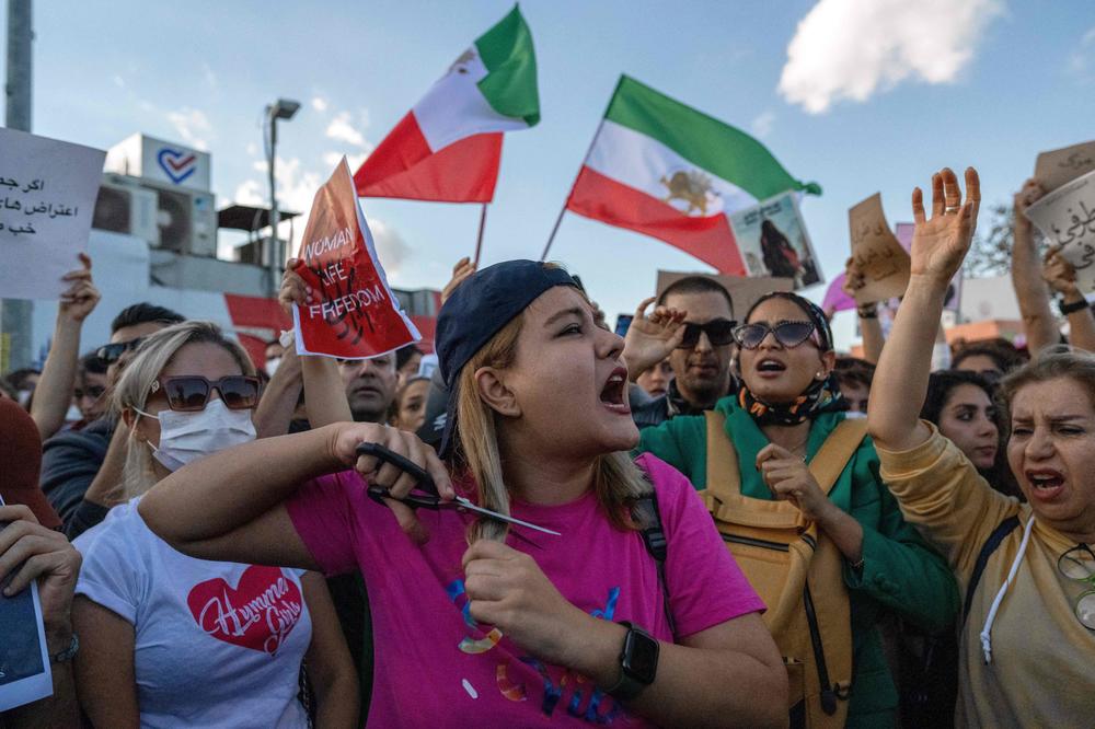 A protester in Istanbul cuts her hair during a demonstration against the Iranian regime and in support of Iranian women on Sunday. Hundreds took to the streets in Turkey to condemn Iran's crackdown on women-led demonstrations, sparked by the death of Mahsa Amini after her arrest by Iran's so-called morality police.