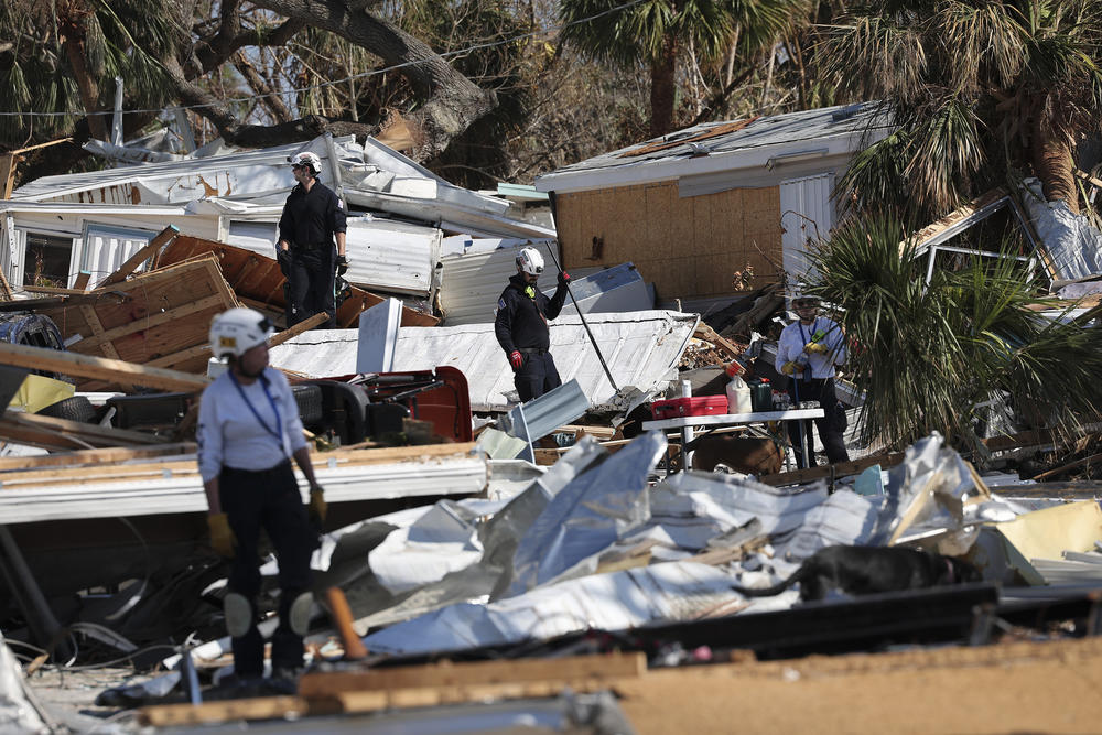 Members of Virginia Task Force 2 Urban Search and Rescue comb through the wreckage on Fort Myers Beach.