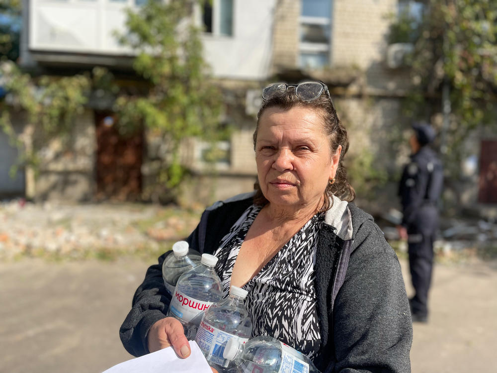 Galina Teliukh, 62, carries drinking water back to her apartment the morning after the top floor of her apartment building was hit by a Russian missile. She says the water that flows through the pipes now is salty and she won't even wash her clothes in it.