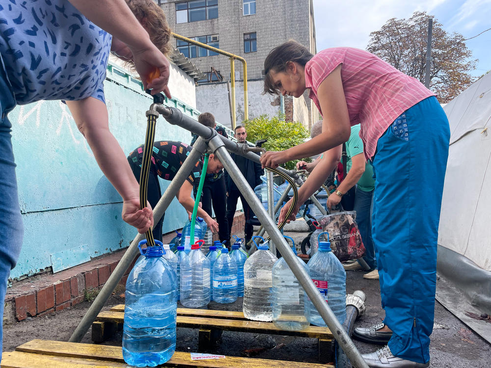 Residents of Mykolaiv collect clean water from a distribution station set up by the International Committee of the Red Cross on Oct. 1.