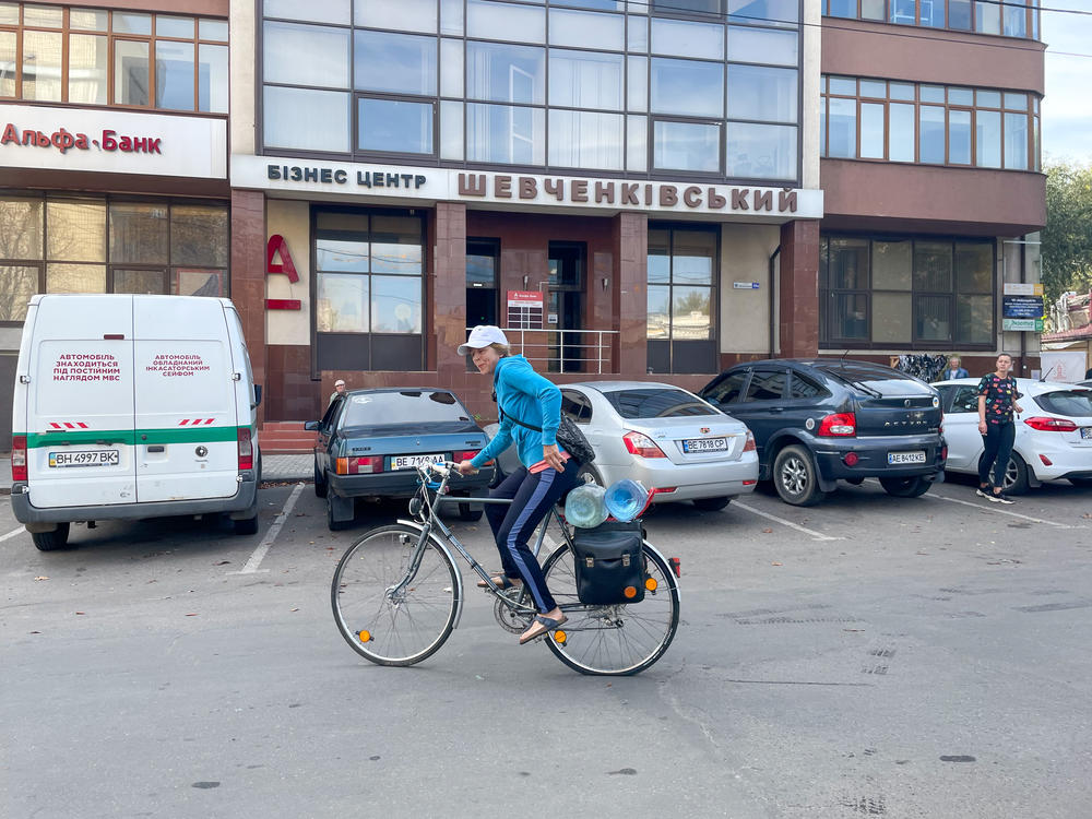 Natalie Rosental, 58, leaves a water distribution station in Mykolaiv on Oct. 1. She rides her bicycle just over a mile each day to fetch water for her family.