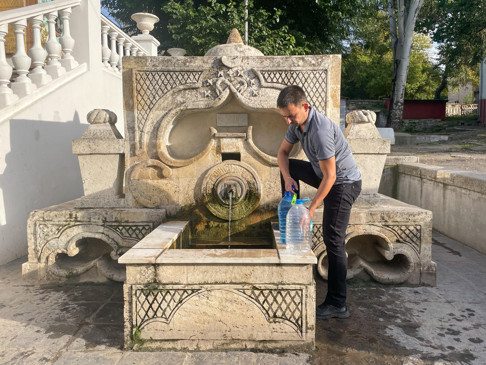 A man fills water bottles from a fountain in Mykolaiv on Oct. 1. The fountain was built at the end of the 18th century at the summer palace of Prince Grigory Potemkin. Some residents say it is still good for drinking, but others are only using it for cooking and cleaning.