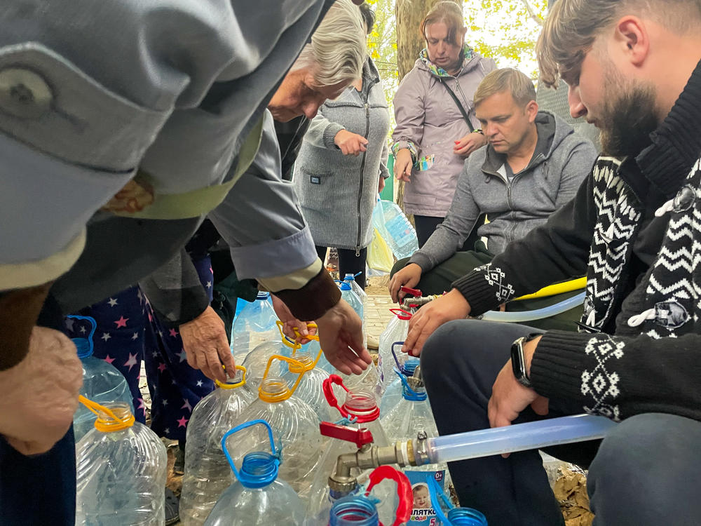 Volunteers distribute water out of the back of a cargo van on a sidewalk in Mykolaiv on Monday.