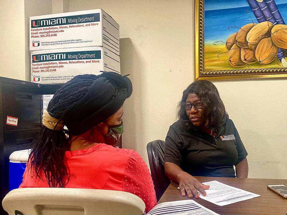 Nicole Daceus, who was recently tested for HPV through the University of Miami's Sylvester Comprehensive Cancer Center, speaks with Valentine Cesar (right), a community health worker. Having a culturally competent staff can be key to cutting through health care avoidance and fear, Cesar says.