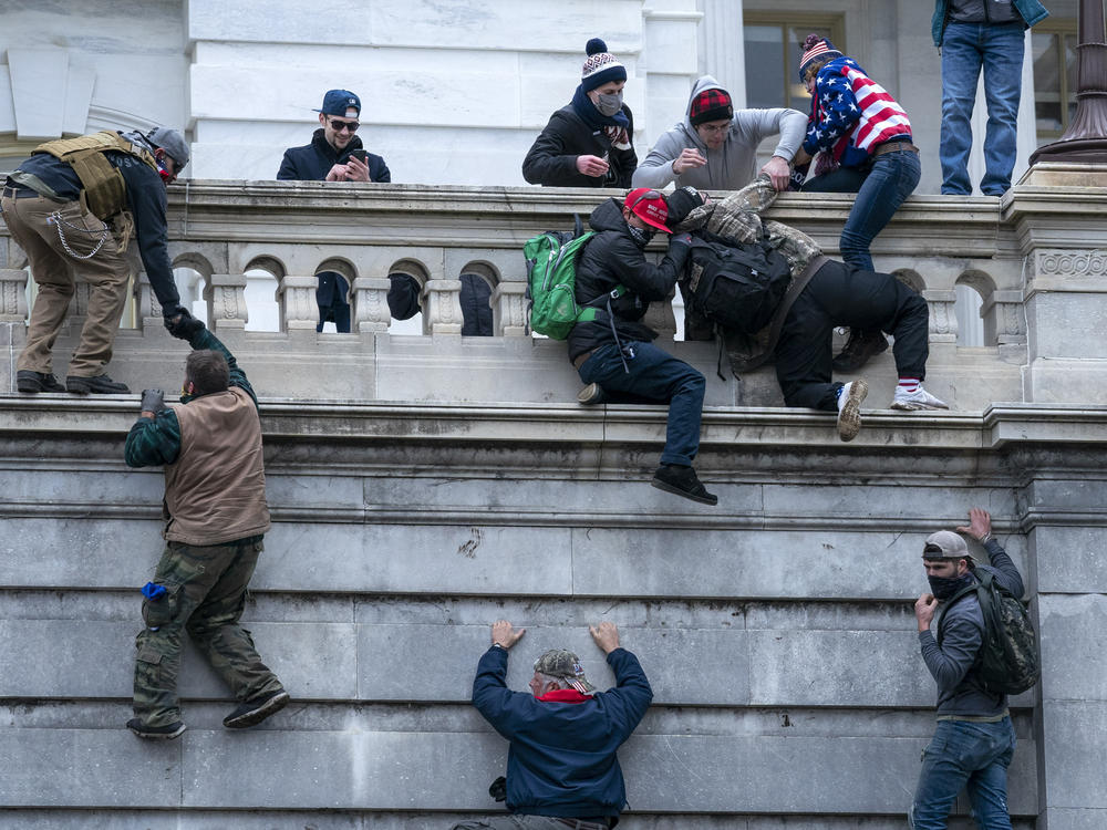 Insurrectionists climb the west wall of the the U.S. Capitol, Jan. 6, 2021, in Washington.