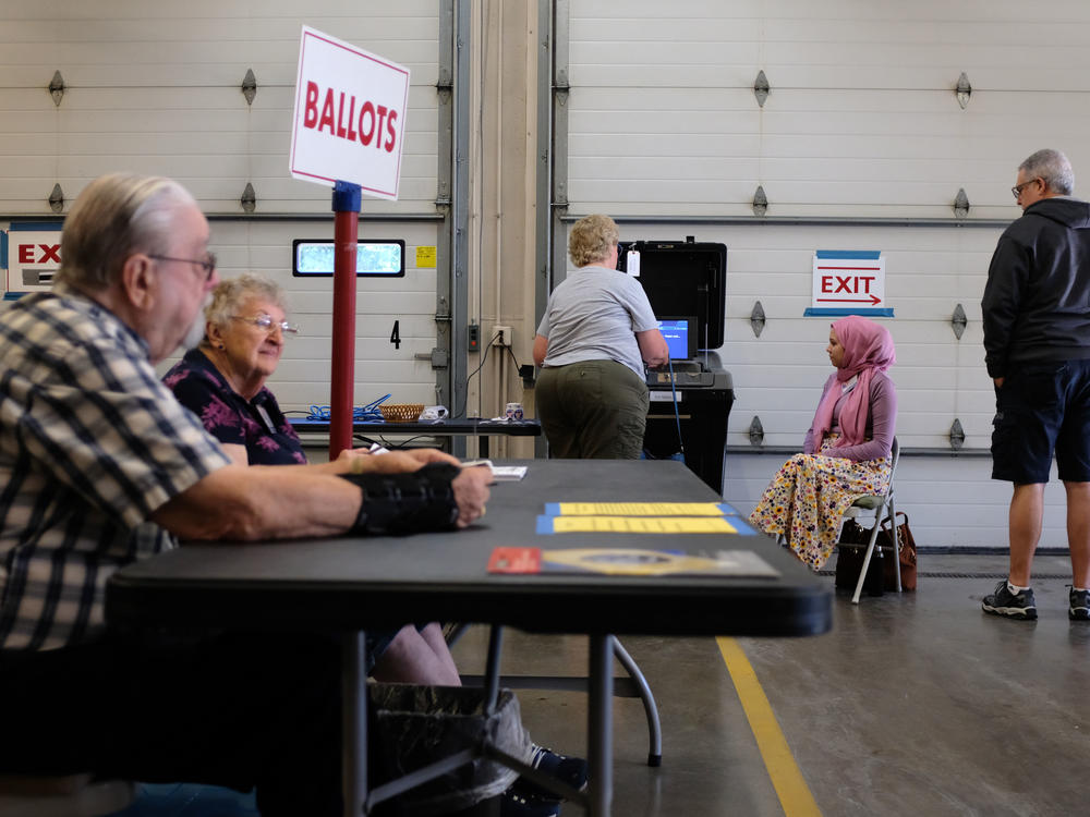 Poll workers and voters are seen during Wisconsin's state primary on Aug. 9. While experts say the overwhelming majority of American poll workers are dedicated to a fair and secure election, some officials are worried about poll worker interference.