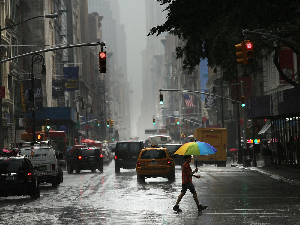 A man walks through the rain during an intense afternoon thunderstorm in 2012 in New York City.