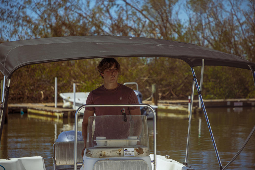 Jake Day steers a boat on his way to clean up his home that was damaged by Hurricane Ian on Little Gasparilla Island, Fla.