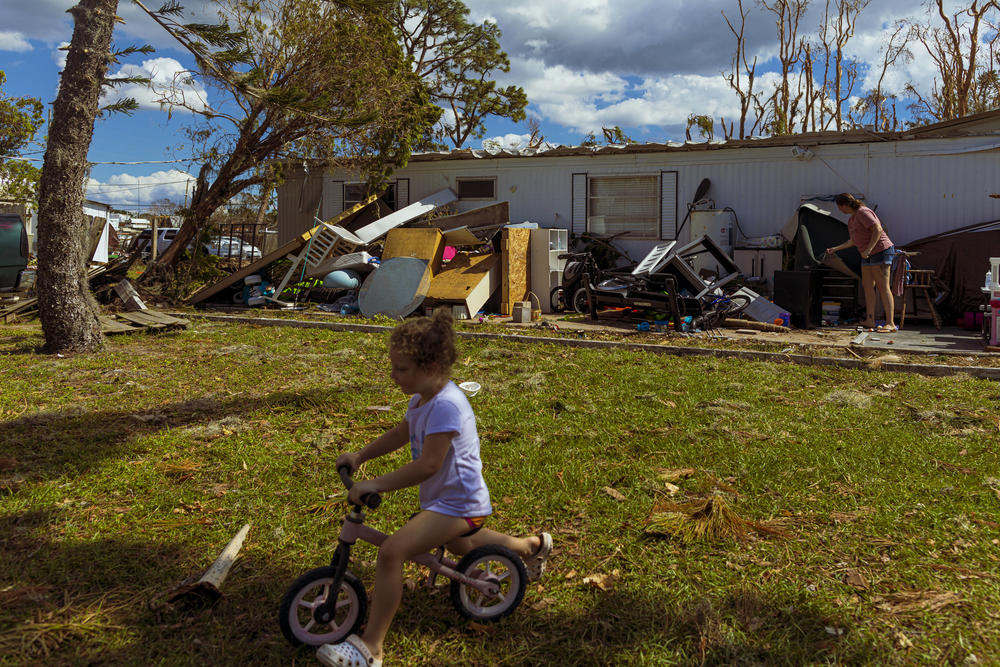 Brianna Eisemann with her daughter Keiyra, as she cleans up their home in the aftermath of Hurricane Ian.