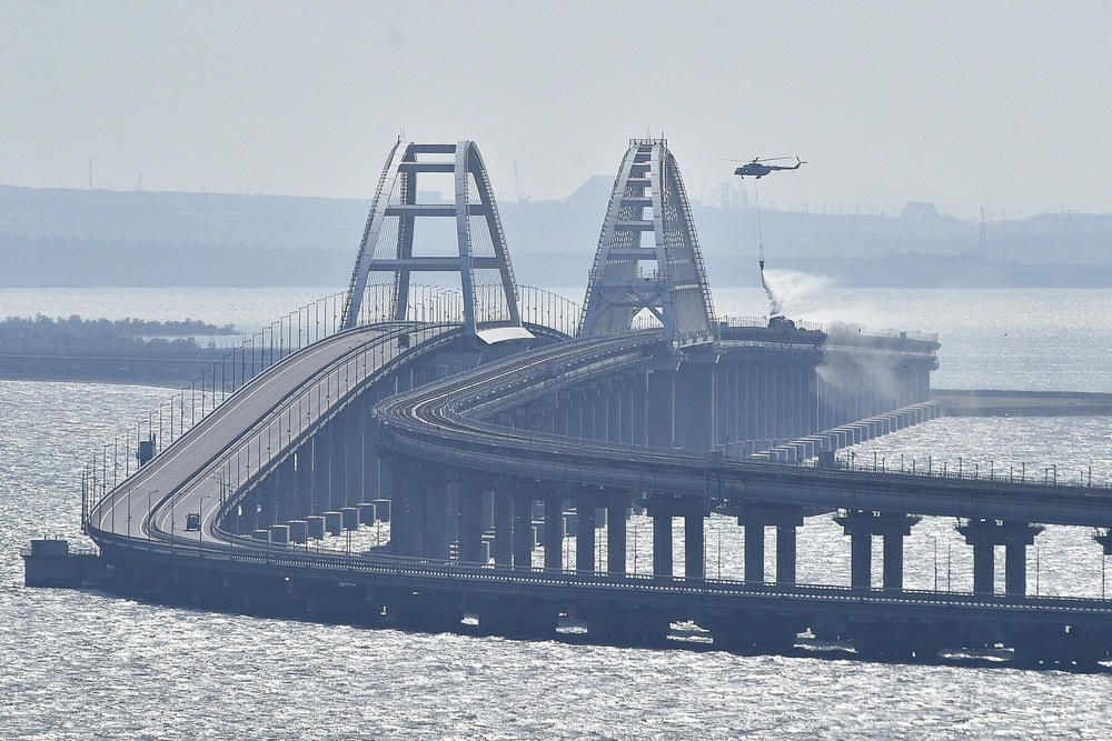 A helicopter drops water to stop fire on Crimean Bridge connecting Russia and the Russia-controlled Crimean peninsula over the Kerch Strait on Saturday.