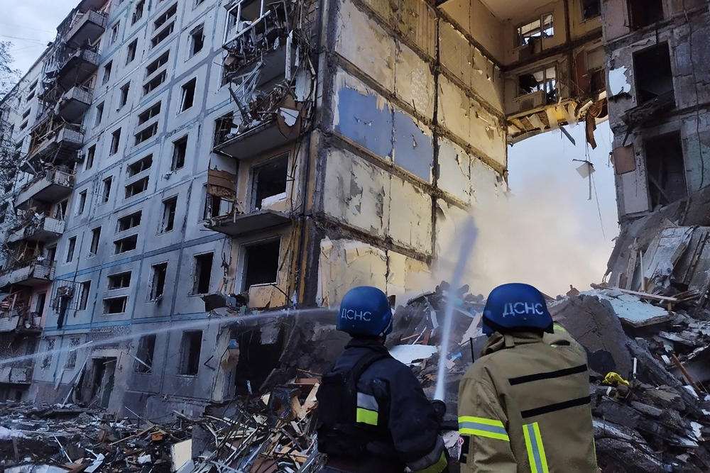 Rescuers use a hose to extinguish a fire in a residential building damaged after a strike in the Ukrainian city of Zaporizhzhia on Sunday.