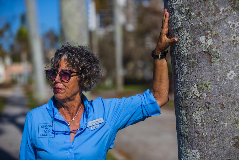 Horticulture specialist Karen Maxwell leans against a royal palm tree. 