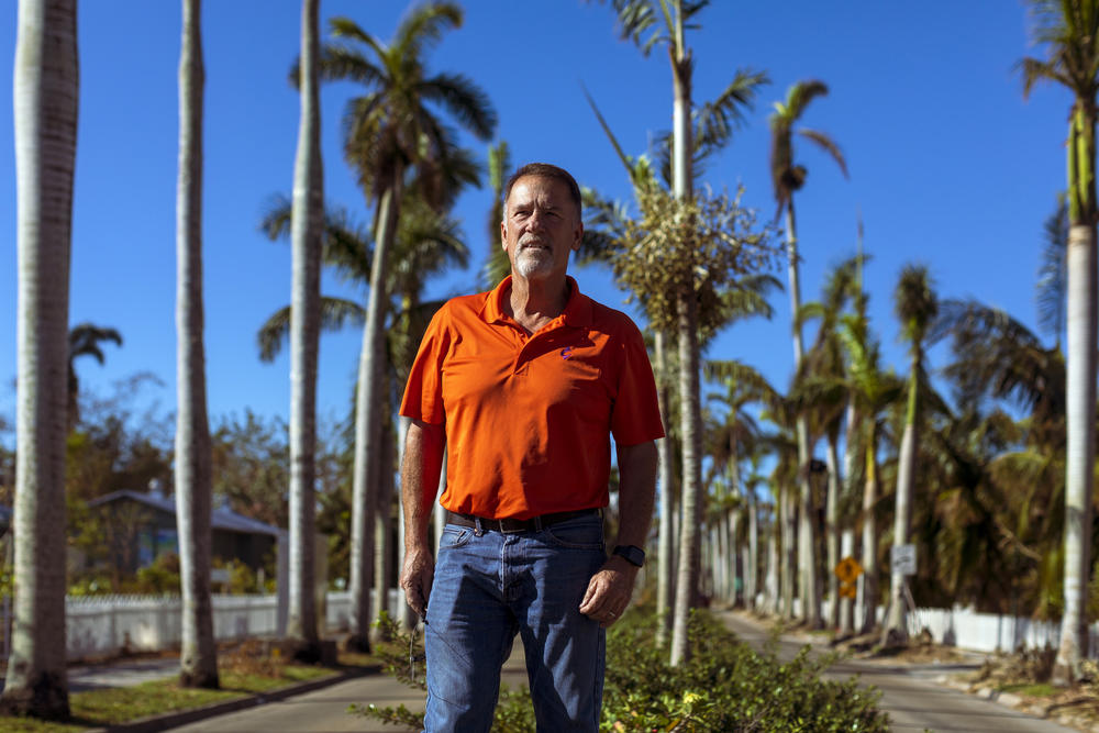 Horticulture specialist Phil Buck stands near rows of royal palm trees in Fort Myers. 