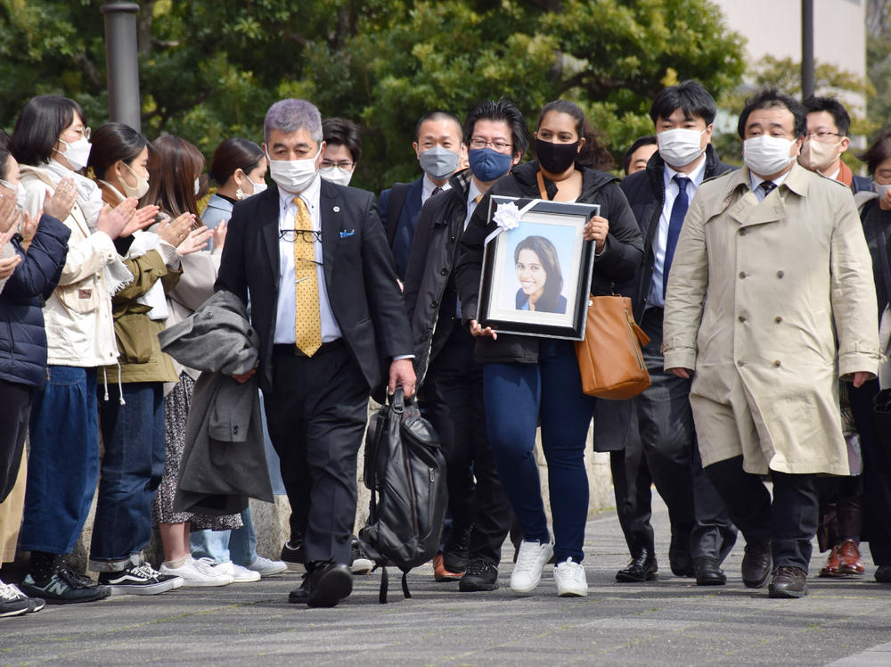 Poorima Sandamali carries a picture of her sister, Wishma Sandamali, a Sri Lankan woman who died while in Japanese immigration detention in 2021, as she walks to the Nagoya district court to file a lawsuit against the government of Japan on March 4.