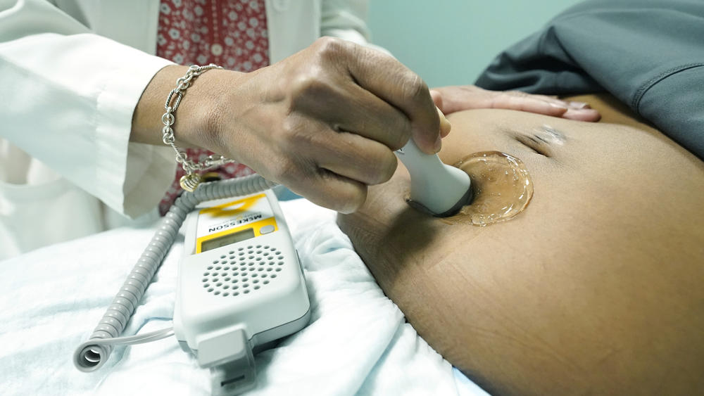 A midwife at Sisters in Birth, a Jackson, Miss., clinic that serves pregnant women, uses a hand-held doppler probe on a patient from Yazoo City to measure the heartbeat of her fetus in 2021.