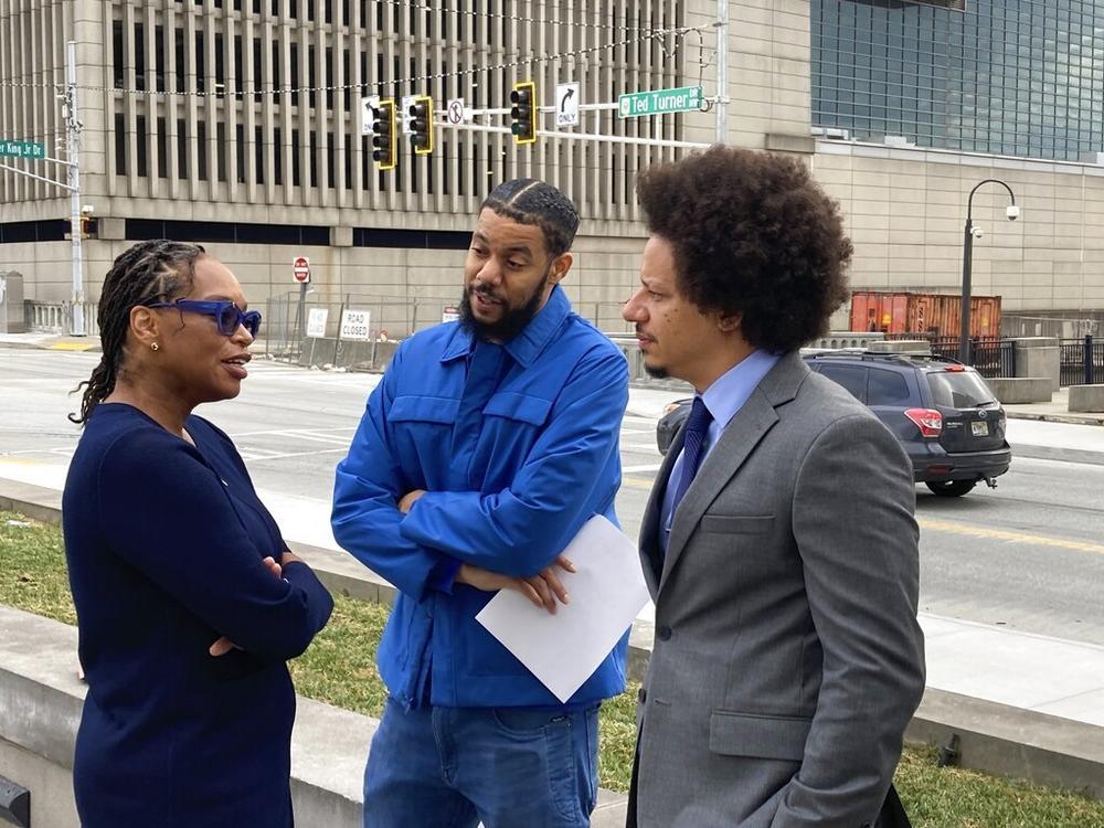 Comedians Clayton English, center, and Eric Andre, right, speak with their attorney, Allegra Lawrence-Hardy, on Tuesday outside the federal courthouse in Atlanta.