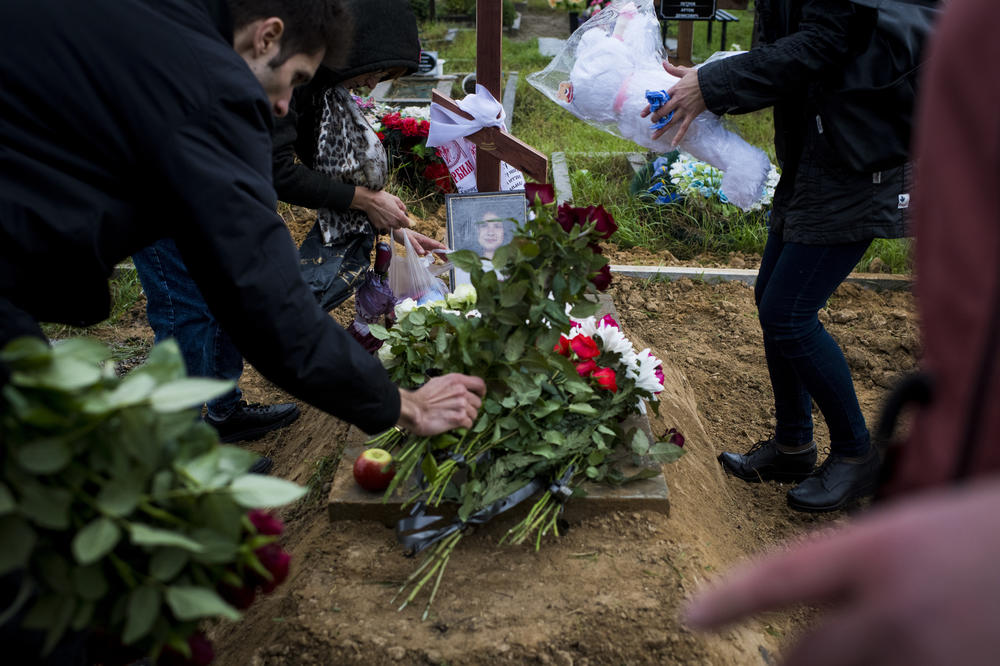 Mourners place flowers and stuffed animals on the grave of 11-year-old Anastasiya Grycenko at her funeral in Kharkiv on Sept. 20.