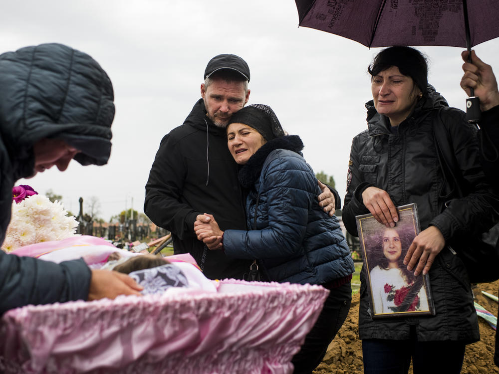 Andriy and Iryna Grycenko (center) mourn the death of their 11-year-old daughter, Anastasiya, at her funeral in Kharkiv, Ukraine, on Sept. 20. Anastasiya was killed on Sept. 17 when a Russian S-300 missile obliterated her home in Chuhuiv. At right is Iryna's sister, Anastasiya's aunt, Rimma Leiba.