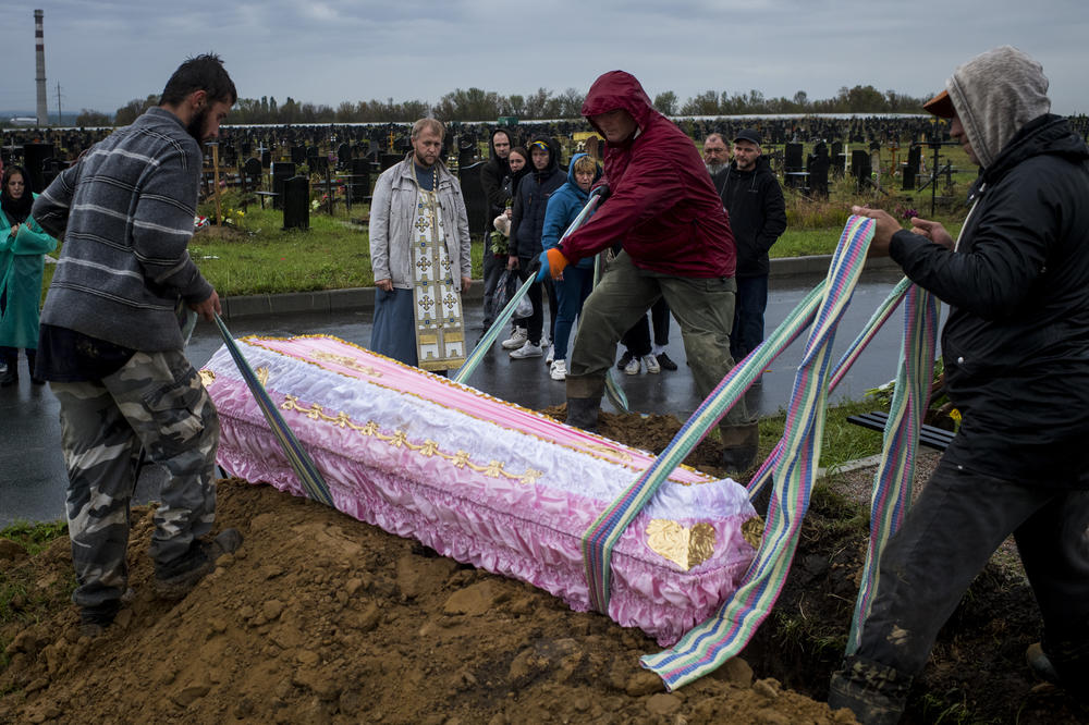 The coffin of 11-year-old Anastasiya Grycenko is lowered into her grave as mourners look on at her funeral in Kharkiv on Sept. 20.