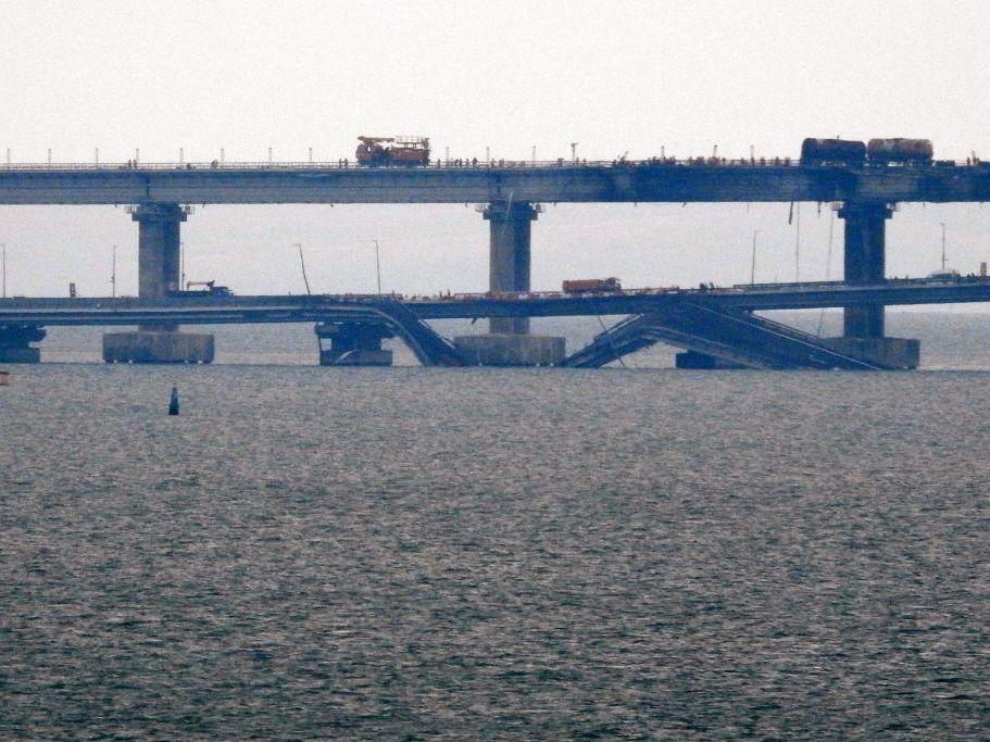 Workers restore the railway tracks Sunday on the Kerch bridge that links Crimea to Russia, a day after it was damaged by a blast. Officials said car and train traffic had resumed over the bridge, with Moscow's transport ministry saying Sunday that long-distance passenger trains from Crimea to Russia were 