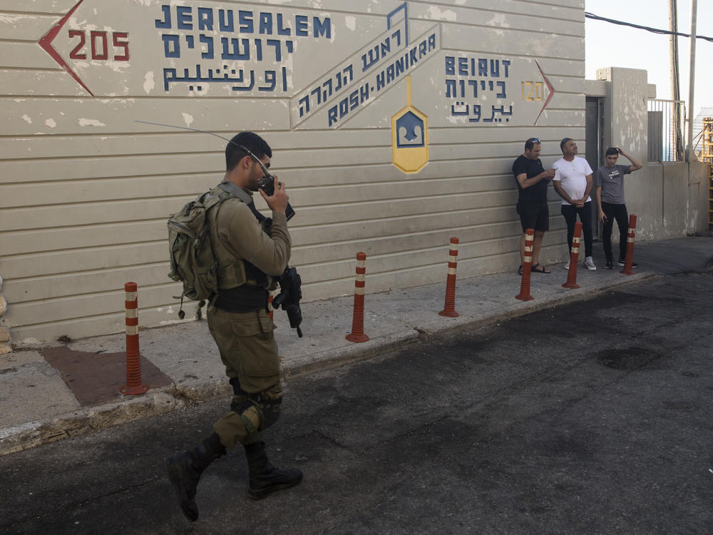 An Israeli soldier walks past a sign at a tourist site at the Israeli side of the border with Lebanon in Rosh Hanikra, Israel, on Tuesday.