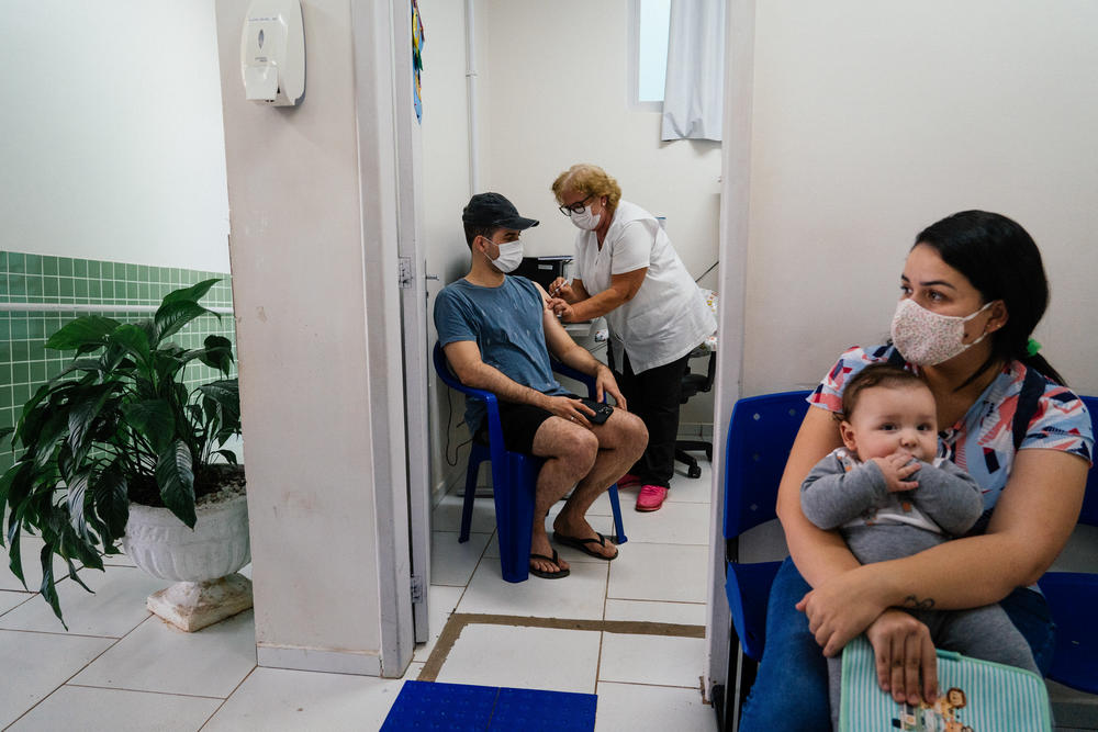 Cassio Oliveira, 28, gets his first COVID booster at a public clinic in Toledo. 