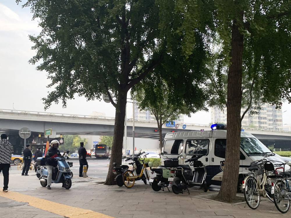A police vehicle is parked near a bridge where social media videos earlier appeared to show smoke and protest banners in Beijing on Thursday. China's internet censors moved quickly to scrub social media posts after reports of banners criticizing the Communist leadership being hung from a busy intersection in the capital Beijing.