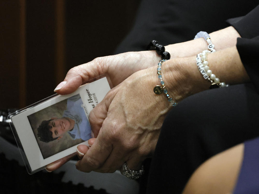 Gena Hoyer holds a photograph of her son, Luke, who was killed in the 2018 shootings, as she awaits the verdict at the Broward County Courthouse on Thursday.