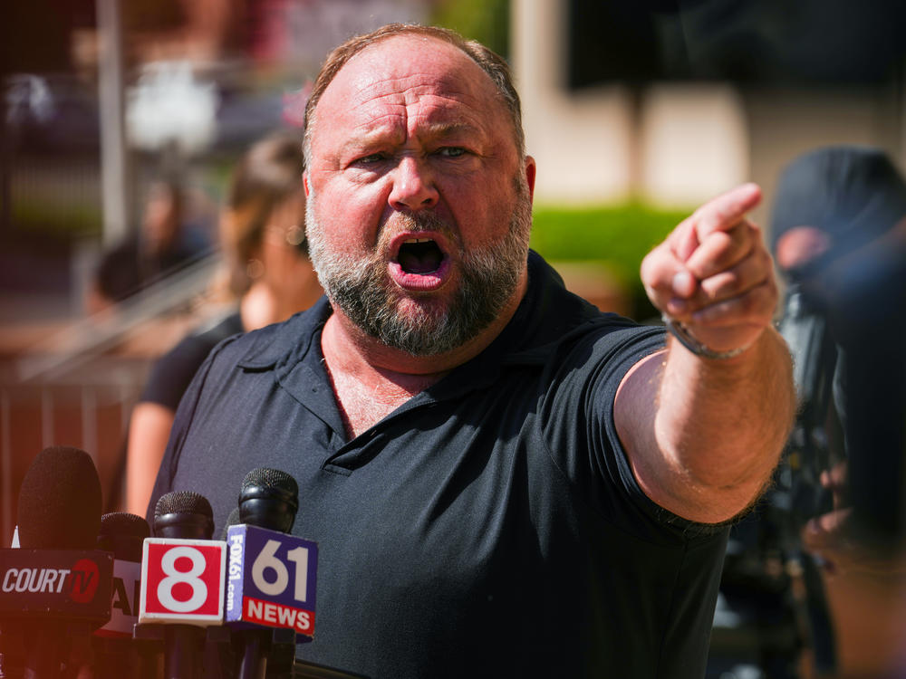 InfoWars founder Alex Jones speaks to the media outside Waterbury Superior Court during his trial last month in Waterbury, Conn.