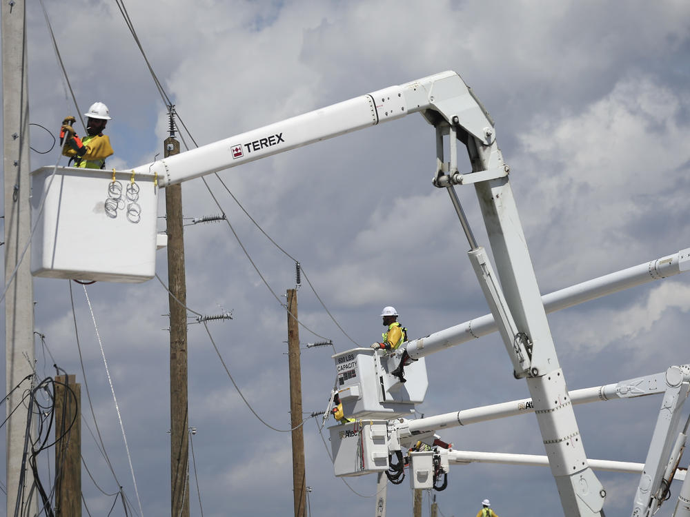 Power crews work to restore electricity in the wake of Hurricane Ian on Oct. 6 on San Carlos Island, in Florida's Lee County.