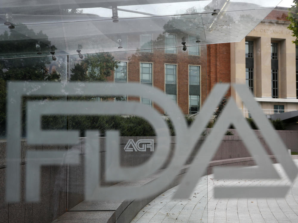 In this Aug. 2, 2018, file photo, the U.S. Food and Drug Administration (FDA) building is visible behind FDA logos at a bus stop on the agency's campus in Silver Spring, Md.