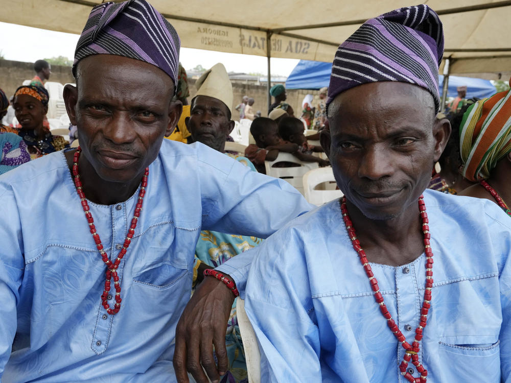 Twins Kehinde Oyediran, left, and Taiwo Oyediran, 52, cassava farmers from Igbo-ora attend the annual twins festival in Igbo-Ora South west Nigeria, Saturday, Oct. 8, 2022.