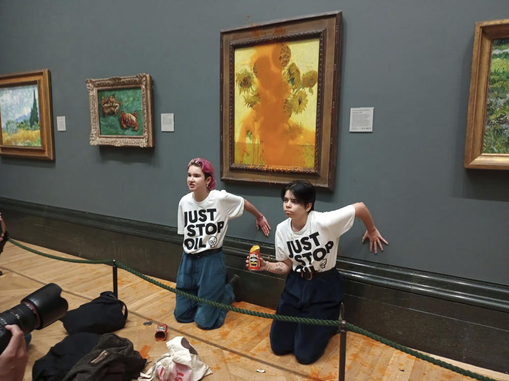 A handout photo issued by the group Just Stop Oil shows two protesters who threw soup at Vincent Van Gogh's famous 1888 work <em>Sunflowers</em> at the National Gallery in London on Friday.