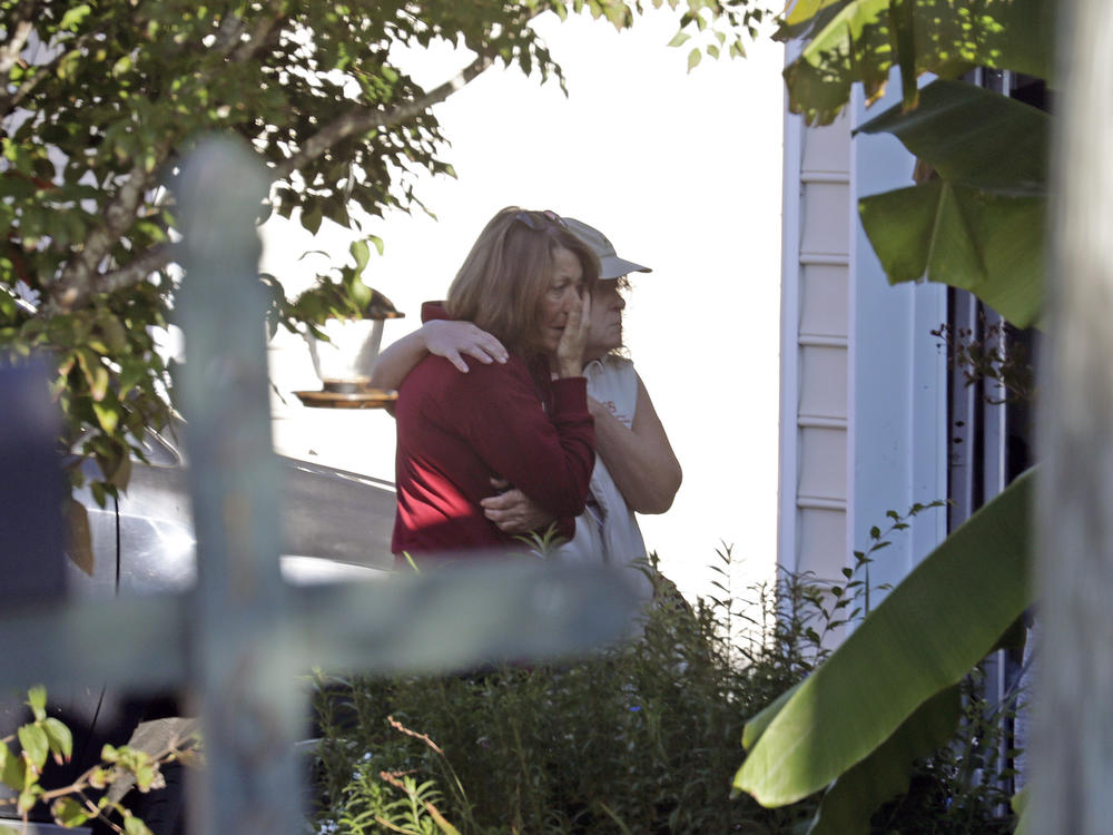 Neighbors embrace on Friday as police continue to investigate  the scene of a shooting that occurred Thursday night in Raleigh, N.C.