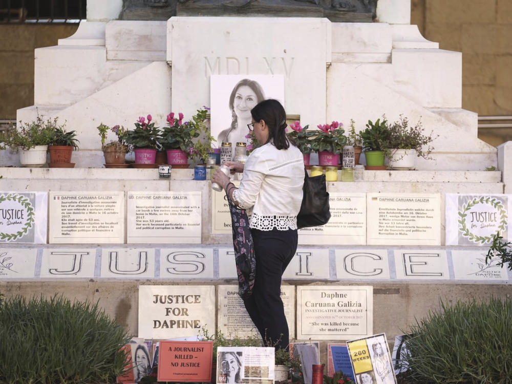 Mandy Mallia, sister of late journalist Daphne Caruana Galizia, lights candles in front of a picture of her sister in Valletta, Malta, on Friday.